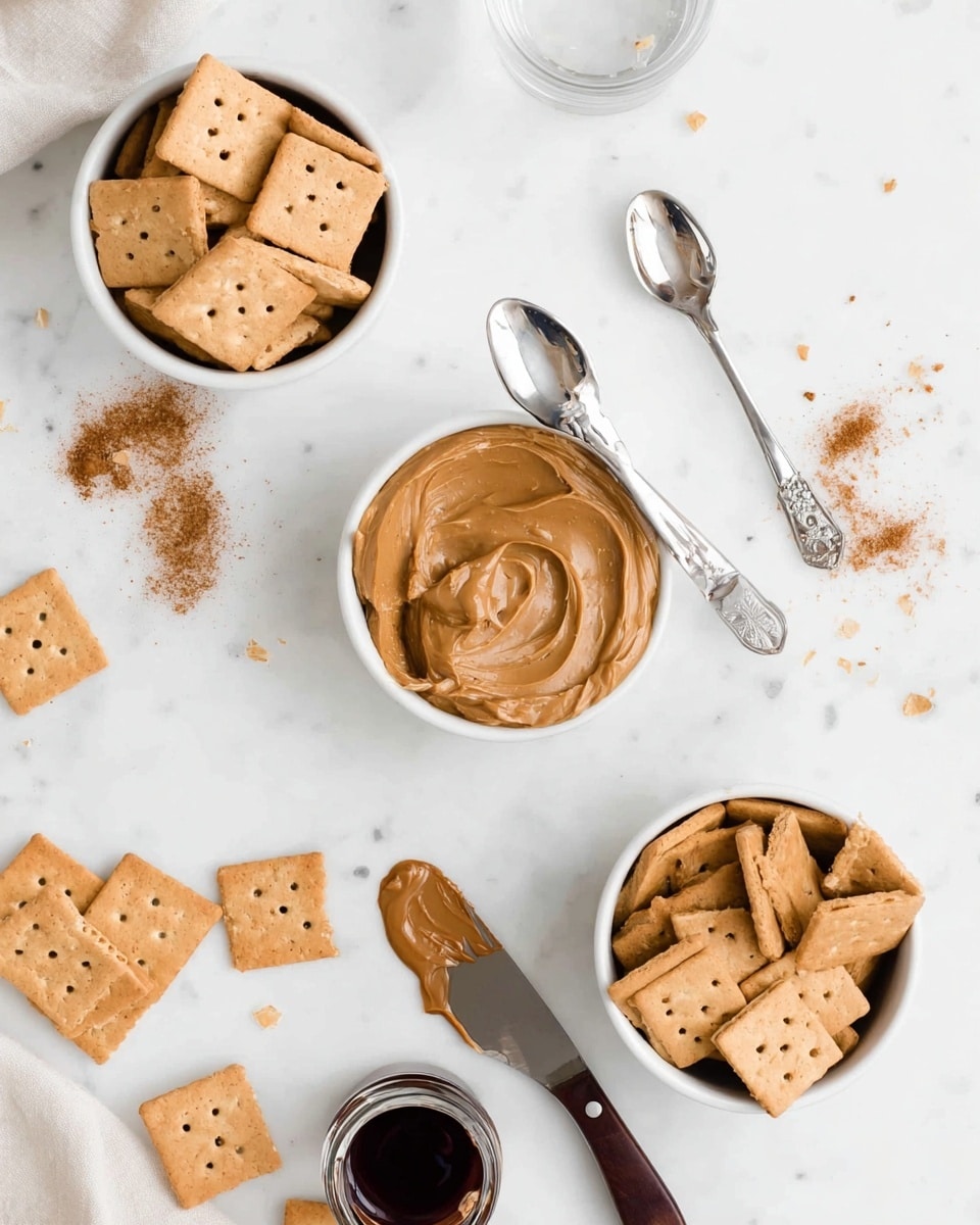 The image shows three white bowls filled with a light brown square cracker, each cracker having small holes in a pattern on top. Two metal spoons lie next to the top middle bowl, one containing a thick peanut butter spread with a smooth, creamy texture and light brown color. A butter knife with dark brown chocolate spread on its tip rests near the bottom right bowl. Scattered around the bowls are a few crackers, some small amounts of cinnamon spice on two measuring spoons, a small clear glass of water, and a small container with a dark liquid, likely syrup. The surface is a white marbled texture, creating a clean and bright setting. Photo taken with an iphone --ar 4:5 --v 7