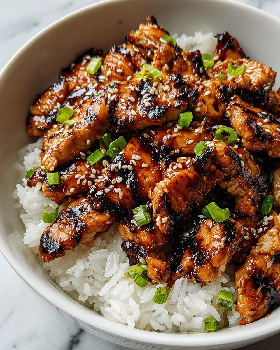 A white bowl filled with two main layers: the bottom layer is soft, fluffy white rice with visible grains, and the top layer consists of grilled chicken pieces coated in a shiny, dark golden-brown glaze with charred marks. The chicken pieces are scattered with small white sesame seeds and bright green chopped scallions, adding color contrast. The bowl sits on a white marbled surface. photo taken with an iphone --ar 4:5 --v 7