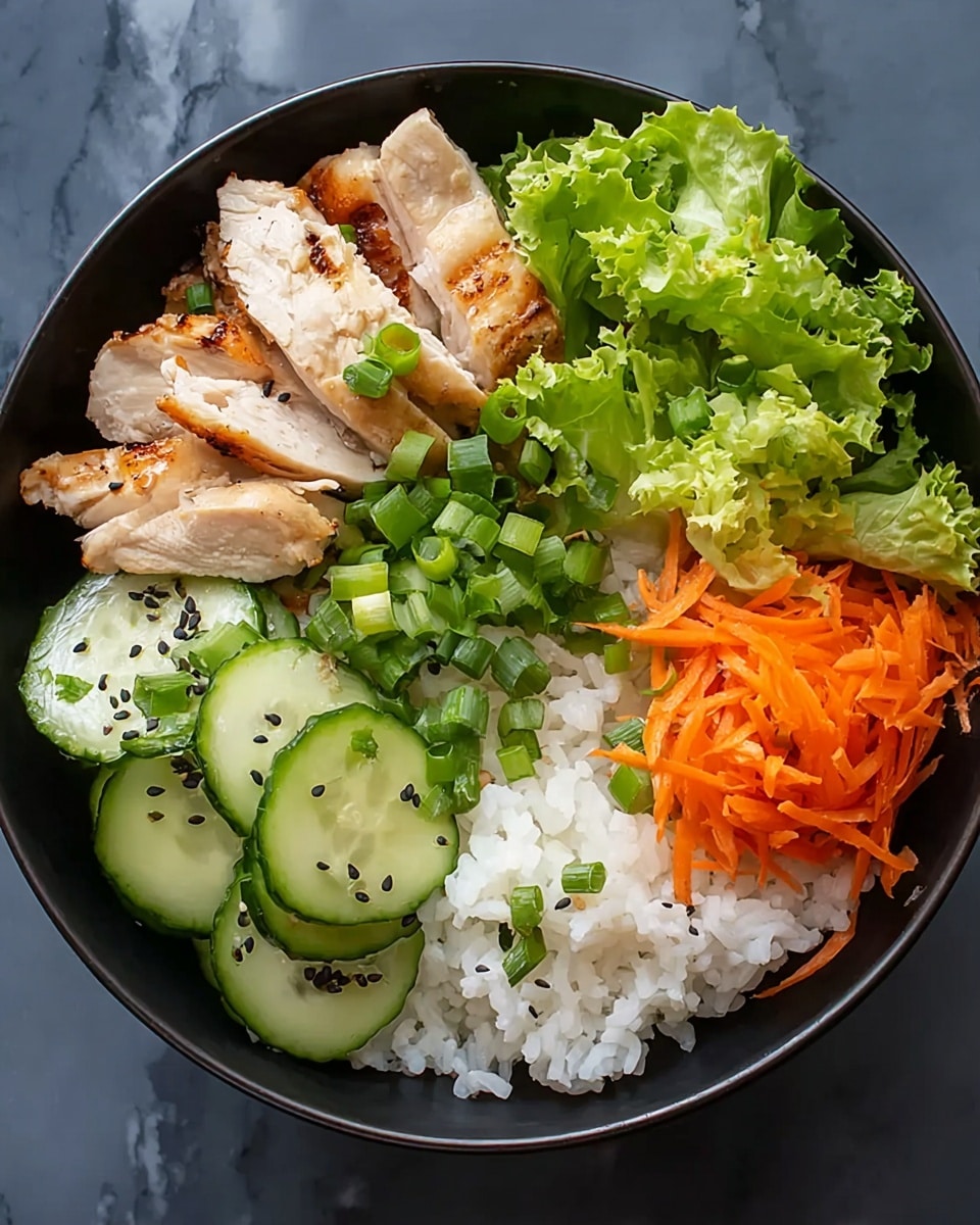 A black bowl filled with five main layers: white cooked rice at the bottom right, thin orange carrot strips piled next to the rice on the right side, green leafy lettuce with a rough texture at the top right, sliced grilled chicken with a light brown outer color and white inside on the top left, and sliced cucumbers with dark green skin and light green inside at the bottom left. The dish is garnished with chopped green onions scattered over the chicken, lettuce, and rice, along with some black sesame seeds sprinkled mostly on the cucumber and chicken. The bowl rests on a white marbled surface. Photo taken with an iphone --ar 4:5 --v 7